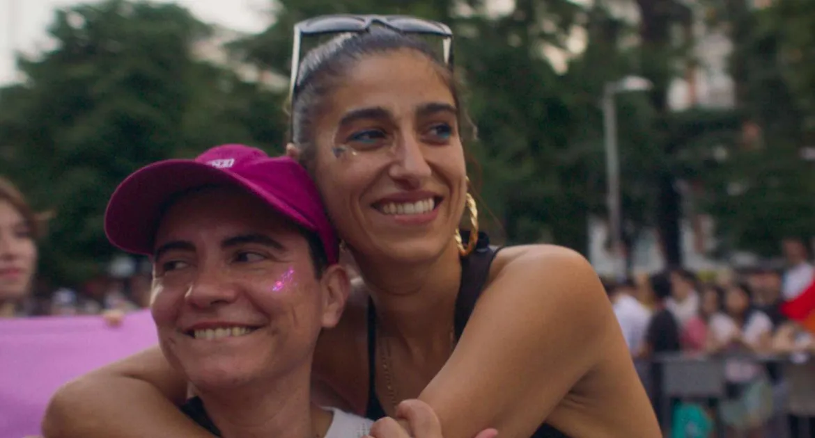 Dos mujeres se abrazan en un contexto festivo