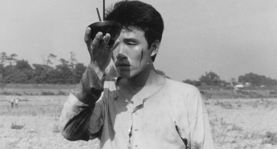 Imagen en blanco y negro de un hombre oriental que sujeta un cuenco en la mano