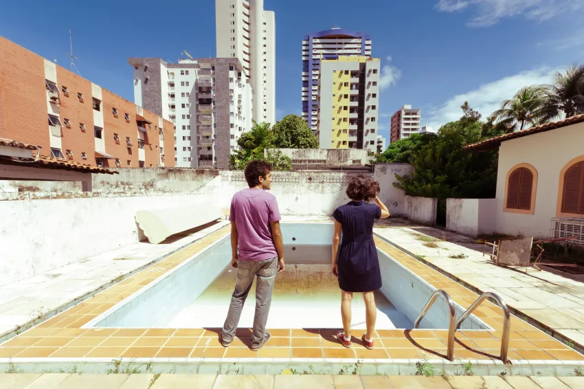 Una pareja observa una piscina vacía